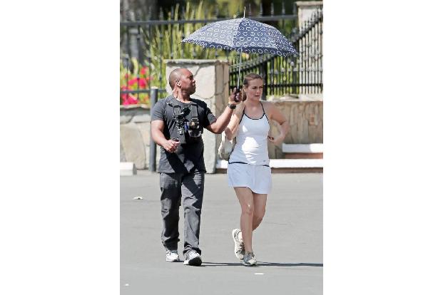 ...wie eine Alicia Silverstone auf dem Weg zum Tennis. Ob der arme Kerl an ihrer Seite ihr auch Schirm haltend beim Sporteln...