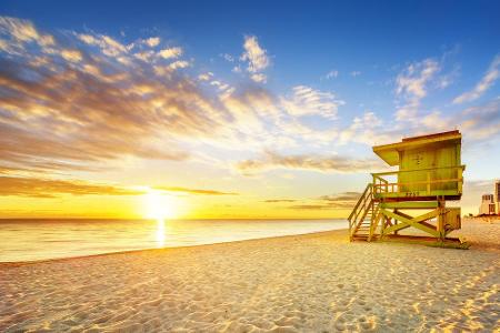 Herzlich willkommen in Miami Beach. Die Sonne geht langsam über dem Horizont auf, der Strand wartet auf die vielen Sonnenhun...