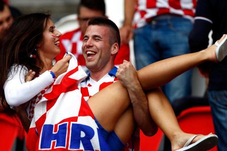 Ein kroatischer Fan übt mit seiner Liebsten beim Türkei-Spiel auf der Tribüne schon einmal das Über-die-Schwelle-Tragen. Kla...