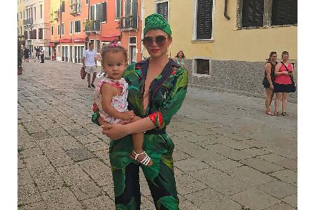 Chrissy Teigen genießt ihren Venedig-Urlaub mit Töchterchen Luna in einem Jumpsuit mit Palmen-Aufdruck. Extravagante Hinguck...