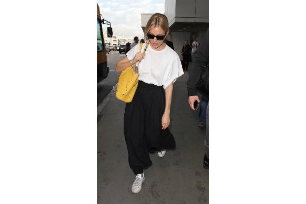 ...auf dem Flughafen beweist Sienna Stil. Der lässige Schwarz-Weiß-Look wurde durch die knallgelbe Tasche noch mal aufgewert...