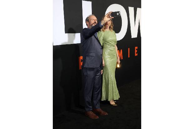 ...Schauspieler Toby Huss auf den Black Carpet der gruseligen Premiere, indem er gut gelaunt Selfies mit seiner Film-Ehefrau...
