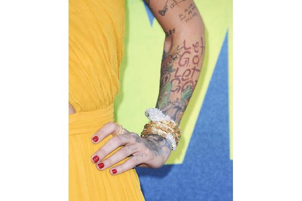 ...Tattoos, die unter anderem aus den Worten 'Let Go' bestanden. Aber auch der prunkvolle Schmuck an ihrem Handgelenk war ei...