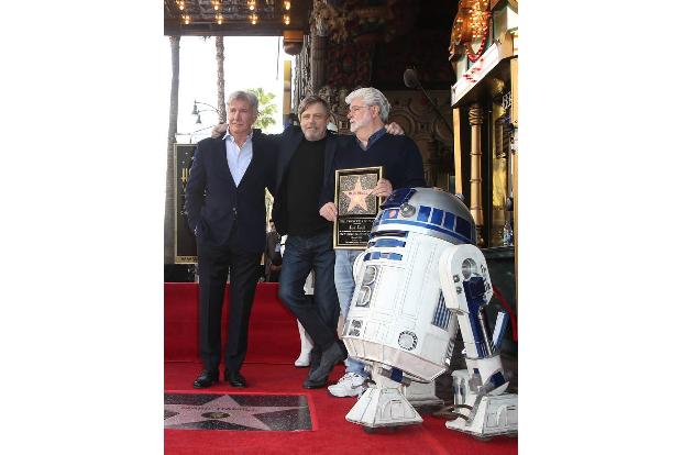 Hier sehen wir den Regisseur mit Harrison Ford, R2D2 und Mark Hamill bei dessen Zeremonie für seinen Stern auf dem Hollywood...