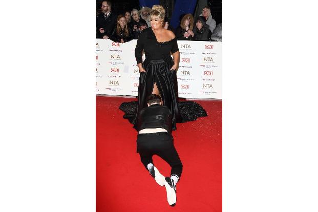 Und Reality-Star Gemma Collins fiel ein Helfer zu Füßen, um ihr Kleiderproblem bei den National Television Awards zu beheben...