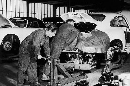 1960: Zwei Mechaniker bauen den Motor in einen 356 B - In den Anfangsjahren waren die Produktionsanlagen noch recht bescheiden.