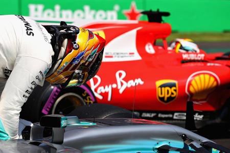 Vis-à-vis mit WM-Konkurrent Sebastian Vettel steigt Lewis Hamilton nach dem Qualifying aus seinem Silberpfeil.