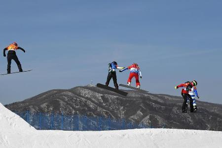 Was aussieht wie eine schlechte Fotomontage, ist Olympia-Action pur! Die Snowboard-Crosserinnen fliegen über die Piste.