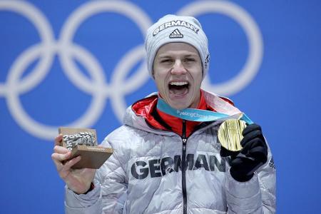 24 Stunden nach seinem Coup von der Normalschanze bekommt Andreas Wellinger die erste olympische Goldmedaille seines Lebens ...