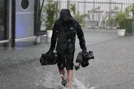 Kamera-Teams und Journalisten kämpfen ebenfalls mit den Wassermassen.