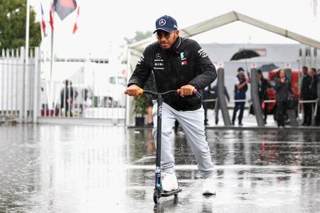 Lewis Hamilton nimmt's lockerer und fährt mit einem Mini-Roller zur Box.