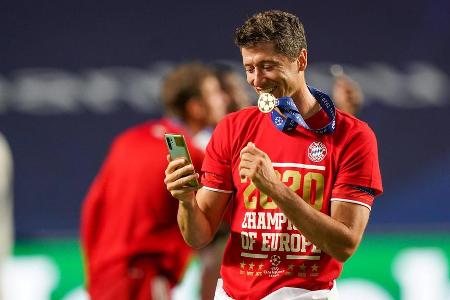 Grüße an die Liebsten? Robert Lewandowski mit Smartphone auf dem Feld.