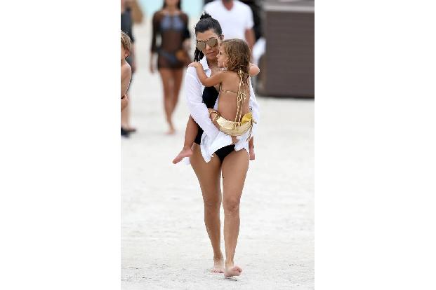 ...Kourtney zeigt uns, wie man am Strand wirklich stylisch sein kann. Nicht auf Bikinis wie an ihrer Tochter fällt dabei ihr...