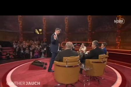 Sichtlich besorgt kehrt er in die Diskussionsrunde zurück und erkundigt sich nach dem Anliegen des Protestlers.