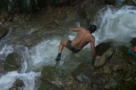 Ailton springt in den reißenden Fluss um sich zu waschen.