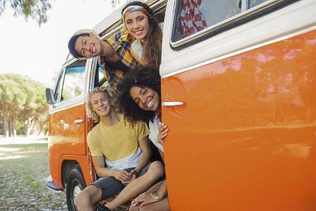 Vier junge Erwachsene in einem alte Campingbus