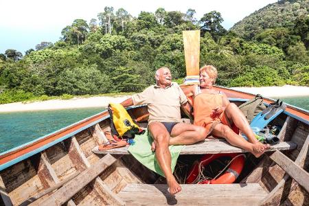 glückliches Rentnerpaar auf einem Boot in Thailand