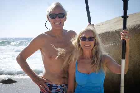 Portrait of happy senior couple holding paddles by the sea m...