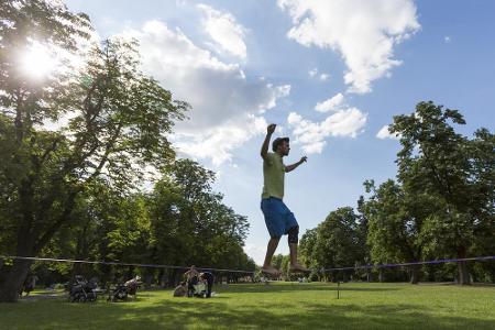 Slackline ist ein relativ neuer Trend. Praktisch: Das elastische Band wird zwischen zwei Bäumen gespannt, die Schatten spenden.