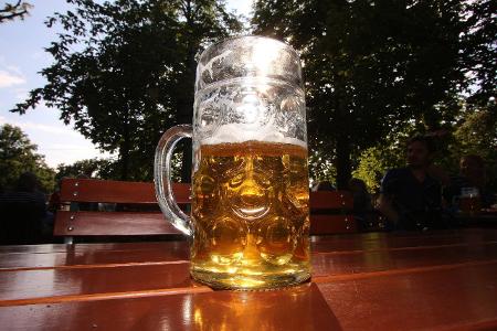 Halbvolle Mass Bier wird vom Sonnenlicht durchleuchtet im Bi...