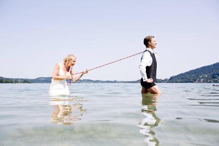 Germany, Bavaria, Tegernsee, Wedding couple standing in lake...