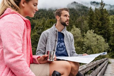 Young couple on a hiking trip with drink and map, Vorderriss...