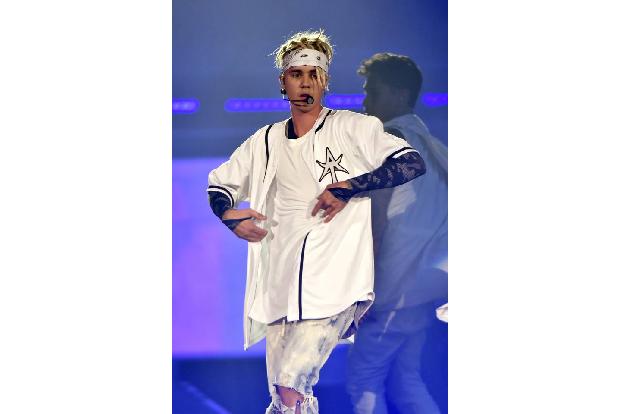 ...zähmte ein in die Stirn gezogenes, weißes Bandana seine in alle Richtungen abstehenden Dreadlocks. Mit diesen trat er ber...