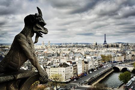 Gargoyle sculpture over Paris cityscape, Ile-de-France, Fran...