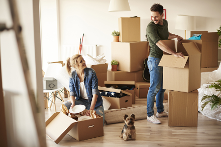 Junges Paar mit kleinem Hund in der neuen Wohnung