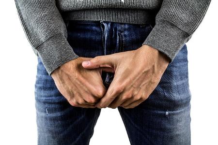 Mann hält die Hände vor sein Genital. Mann hält die Hände vor sein Genital.
