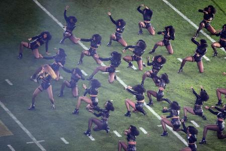 ... Beyonce sorgte für Aufsehen, als sie mit High Heels und begleitet von einer Horde von Tänzern auf dem Gras des Spielfeld...