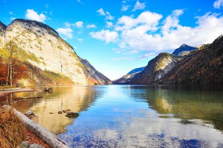 Die Landschaft um den bayerischen Königssee ist spektakulär. Im klaren Wasser spiegeln sich die bunten Blätter des Bergwalde...