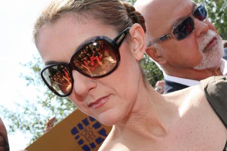 Sängerin Céline Dion schreibt Autogramme mit der linken Hand.