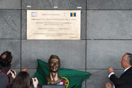 Um die Welt geht allerdings auch das Bild der ziemlich misslungenen Bronze-Skulptur, die im Zuge der Flughafen-Umbenennung e...