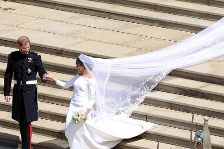 Das Brautkleid, in dem Meghan vor den Altar trat, war ein minimalistisches Seidenkleid mit Bateau-Ausschnitt, Dreiviertelärm...