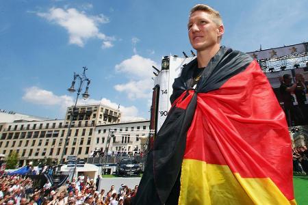 Die Feier der deutschen Nationalmannschaft mit hunderttausenden Fans am Brandenburger Tor führte Schweinsteiger eingehüllt i...