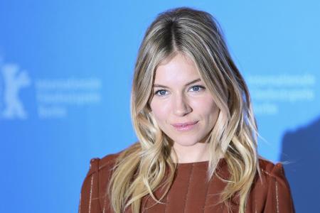 Sienna Miller verleiht das stufig geschnittene lange blonde Haar eine verspielte Note. Durch die Strähnen um ihr Gesicht wir...