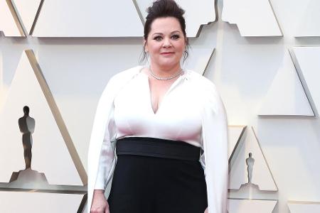 Melissa McCarthy zeigte sich in weißer Bluse mit langem Cape, die sie zur schwarzen High-Waist-Hose kombinierte.