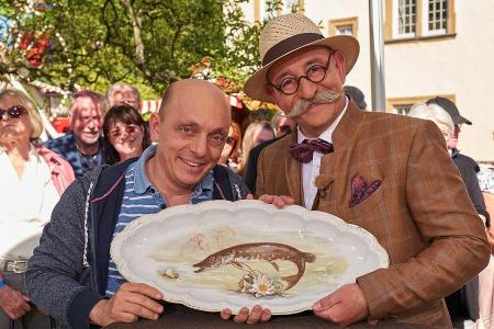 Bernhard Hoëcker (l.) und Moderator Horst Lichter halten den großen Teller in die Kamera