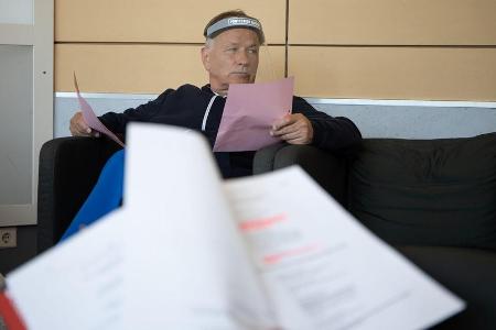 Schauspieler Thomas Rühmann mit Visier bei einer Textprobe.