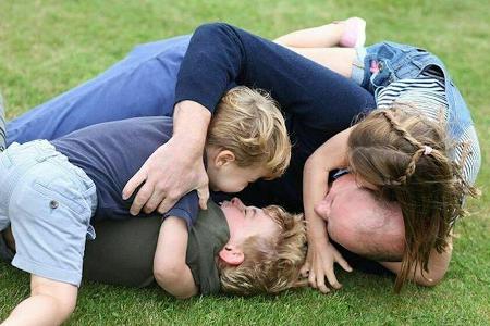 Prinz William tobt mit seinen drei Kindern im Gras. Prinz William tobt mit seinen drei Kindern im Gras.