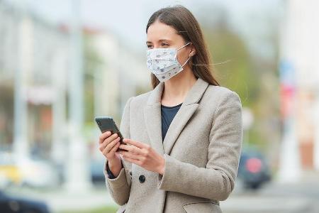 Eine junge Frau benutzt ein Smartphone, um sich zu orientieren (Symbolbild)