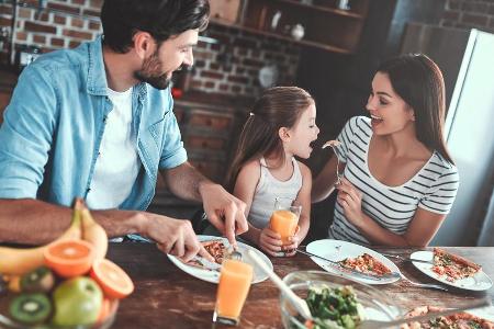 Eine junge Familie mit einer selbst zubereiteten Pizza. Eine junge Familie mit einer selbst zubereiteten Pizza.