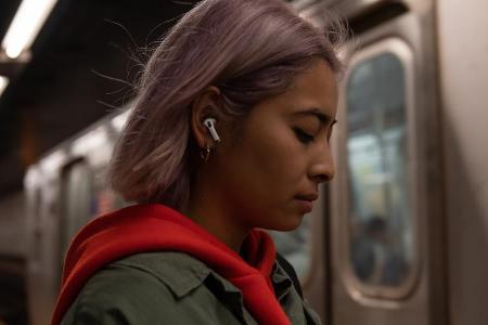 Eine junge Frau trägt die neuen AirPods Pro von Apple