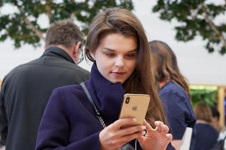 Eine Kundin in London betrachtet die neuen iPhones
