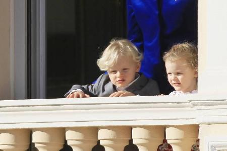 Prinz Jacques (l.) und Prinzessin Gabriella staunen mit Mama Charlène von Monaco vom Balkon herab