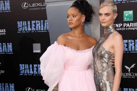 Rihanna (l.) in Rosa, Cara Delevingne im abgespacten Metallkleid