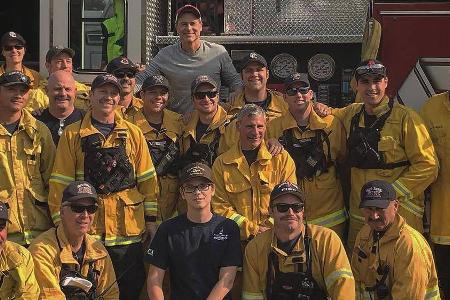 Rob Lowe (hinten Mitte) und sein Sohn Matthew (vorne Mitte) mit den Feuerwehrleuten