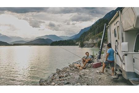 Father and son fishing by a lake