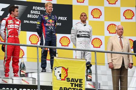 Sebastian Vettel schaut im Jahr 2013 nicht schlecht, als Aktivisten in Spa zwei Transparente auf dem Podium von Spa entrolle...